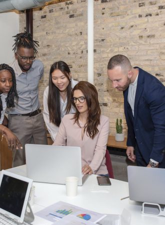 a young entrepreneur sitting in the boardroom with multiethnic coworkers around her discussing new ideas and strategies of their project, cooperation concept
