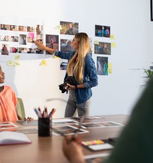 Diverse group of business colleagues brainstorming looking at photos in meeting room. independent creative business in modern office.